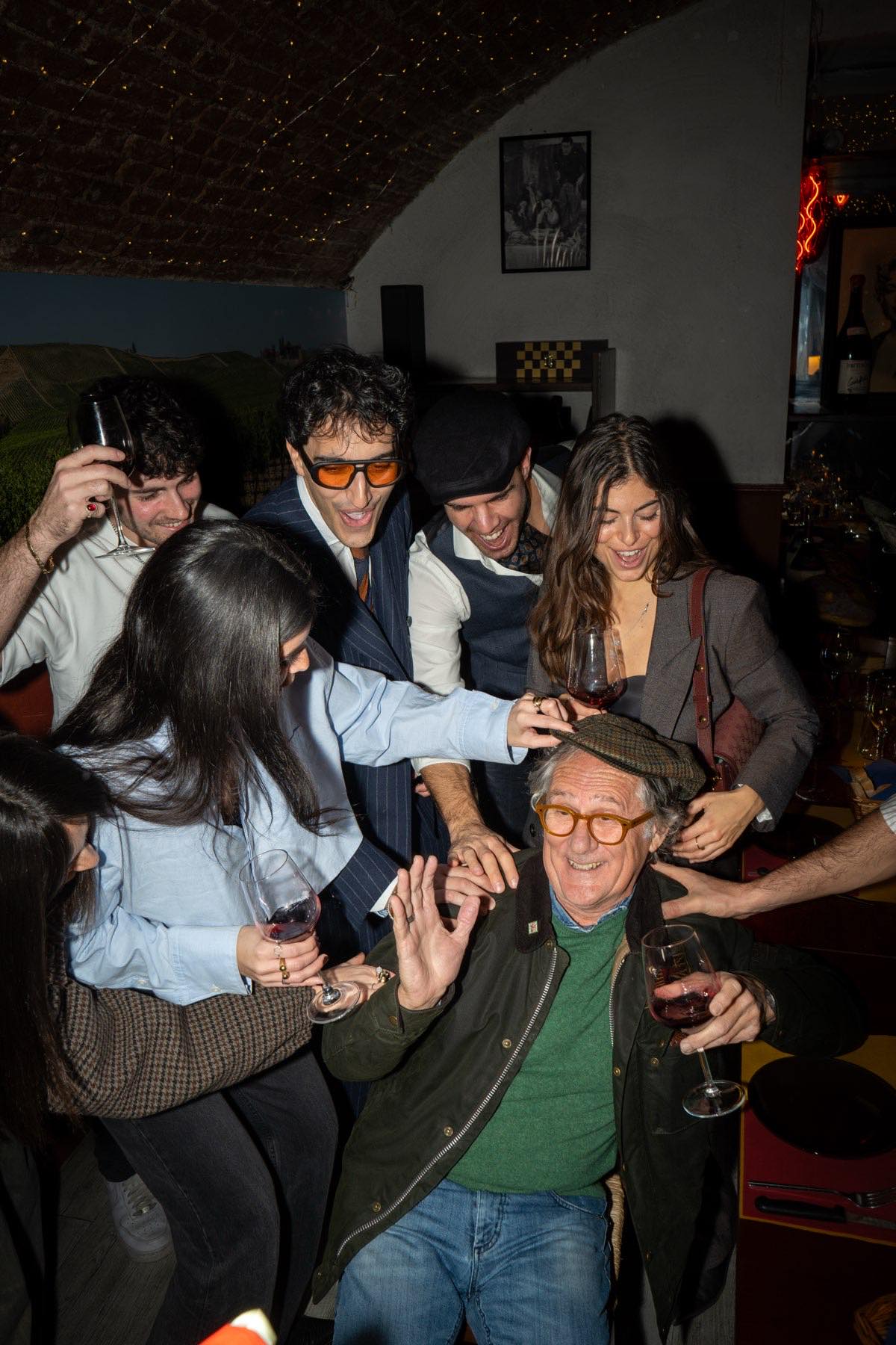 Gruppo di amici brinda ridendo attorno al tavolo