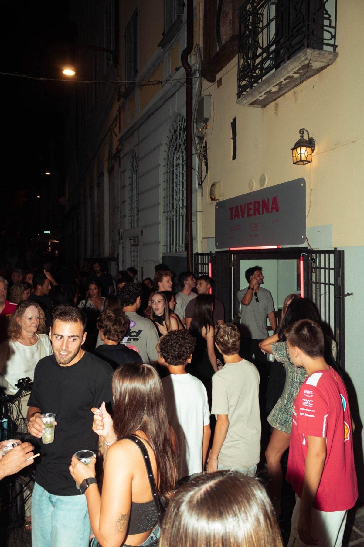 Folla di ospiti all'ingresso di Taverna Felicità in una serata affollata